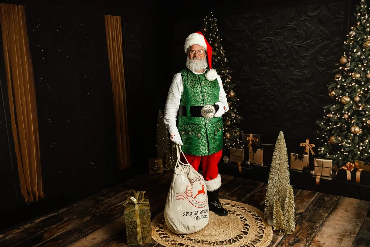 Santa Michael in his green Christmas waistcoat beside his gift sack.